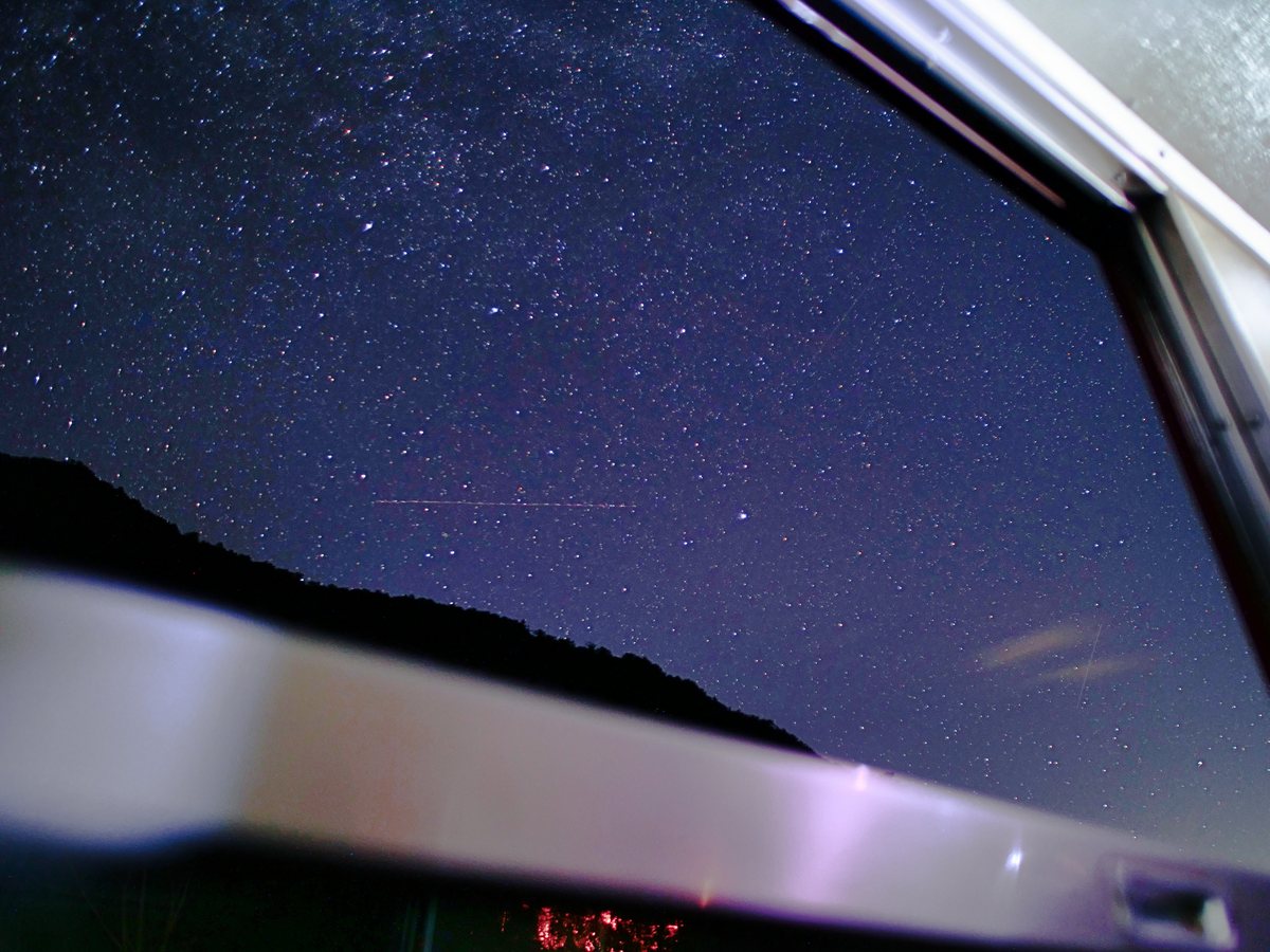 客車の窓いっぱいに広がる星空